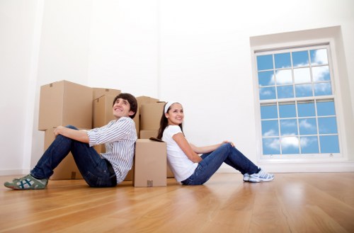 Professional movers transporting household items from a flat or house